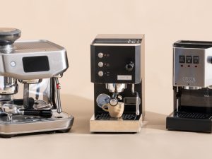 A budget espresso coffee machine beside a fresh cup on a white countertop.