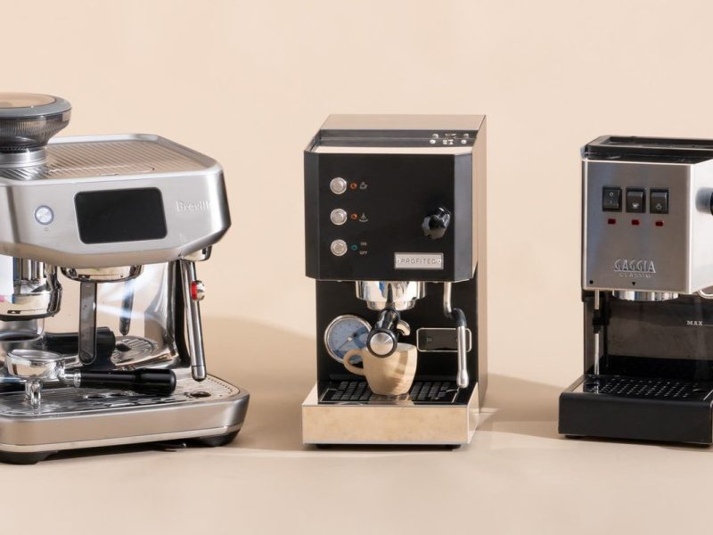 A budget espresso coffee machine beside a fresh cup on a white countertop.